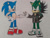 Size: 1032x774 | Tagged: dnp, safe, artist:theoneandonlycactus, sonic the hedgehog, oc, oc:cactus the hedgehog, hedgehog, blue fur, duo, fingerless gloves, gloves, green eyes, green fur, jacket, male, shoes, socks, traditional media