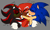 Size: 2048x1231 | Tagged: safe, artist:renegadeknucks, knuckles the echidna, shadow the hedgehog, sonic the hedgehog, blushing, dark skin, gay, green blush, grey background, holding each other, kiss on cheek, knuxadow, knuxonadow, knuxonic, mwah, polyamory, sfx, shadow x sonic, shipping, simple background, smile, top surgery scars, trans male, transgender, trio