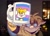 Size: 1049x748 | Tagged: safe, artist:clearmoonbasement, miles "tails" prower, 2024, holding something, hoodie, lidded eyes, meme, middle finger, mug, older, photographic background, redraw, signature, sketch, solo, sparkles, trans male, trans pride, transgender